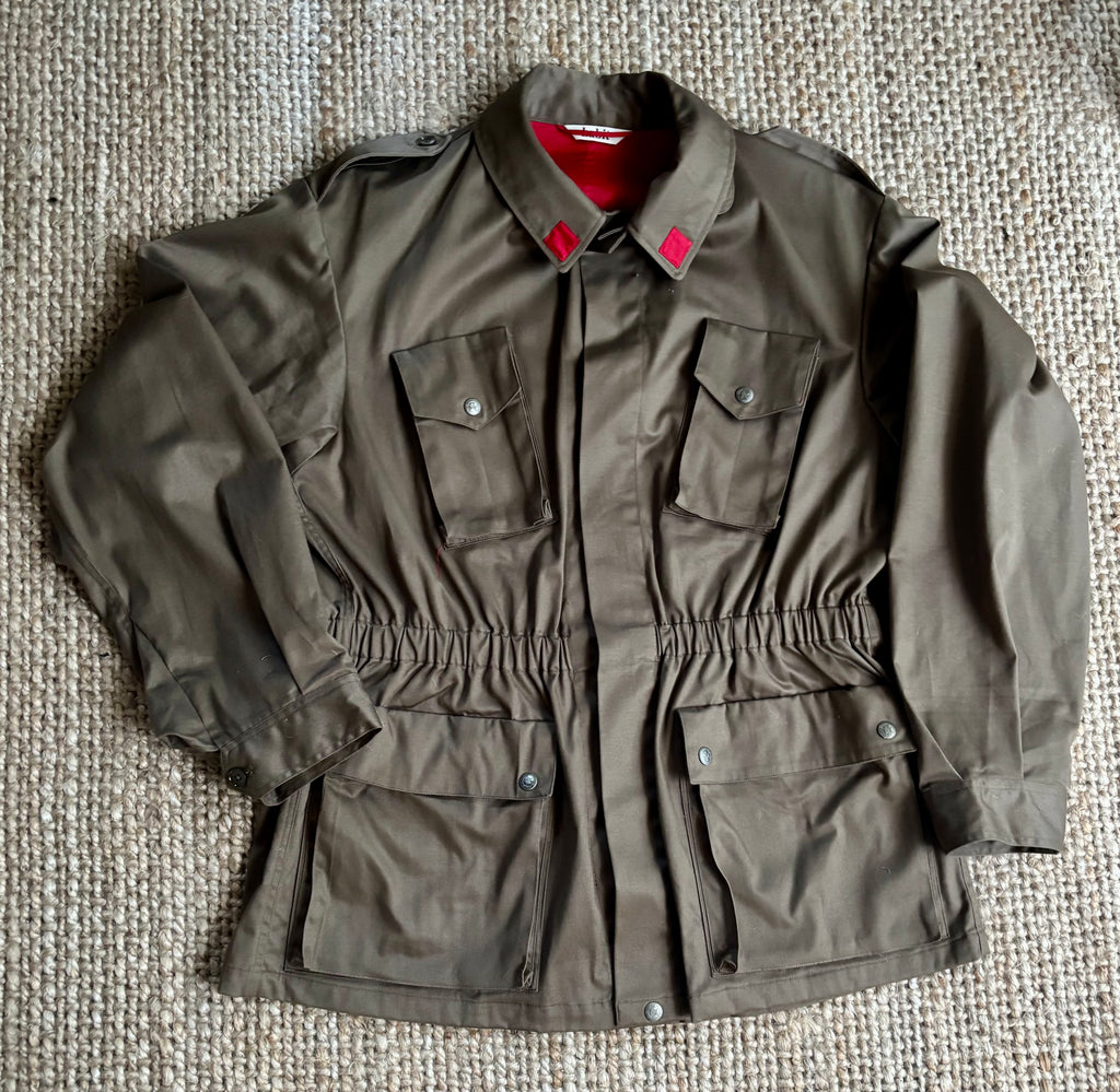 Brown jacket with red lining on a textured beige surface