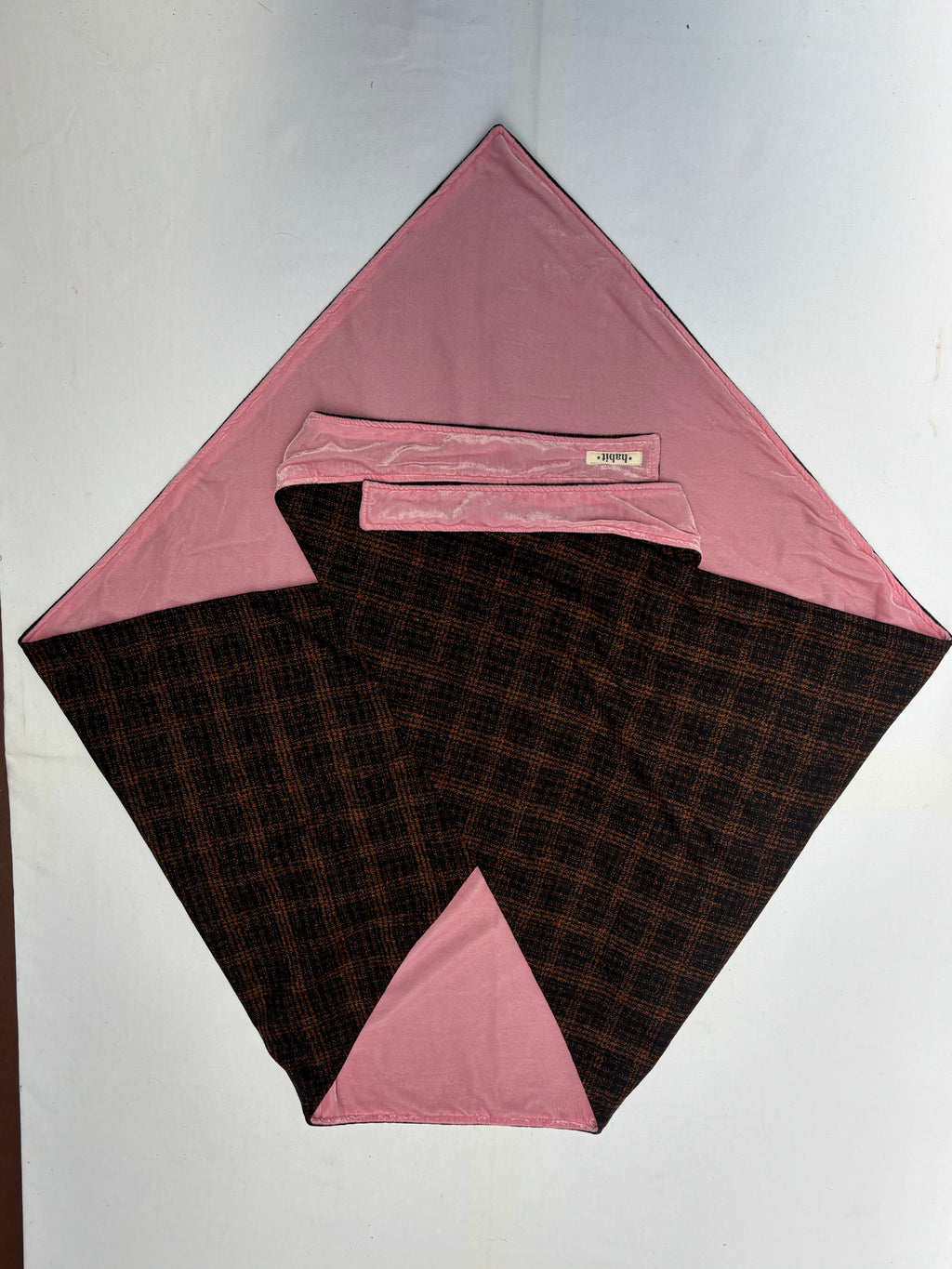 Folded fabric with pink and brown checkered pattern on a white background